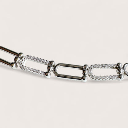 Close up of the U link Pave CZ Silver bracelet with diamond accents on a light gray background