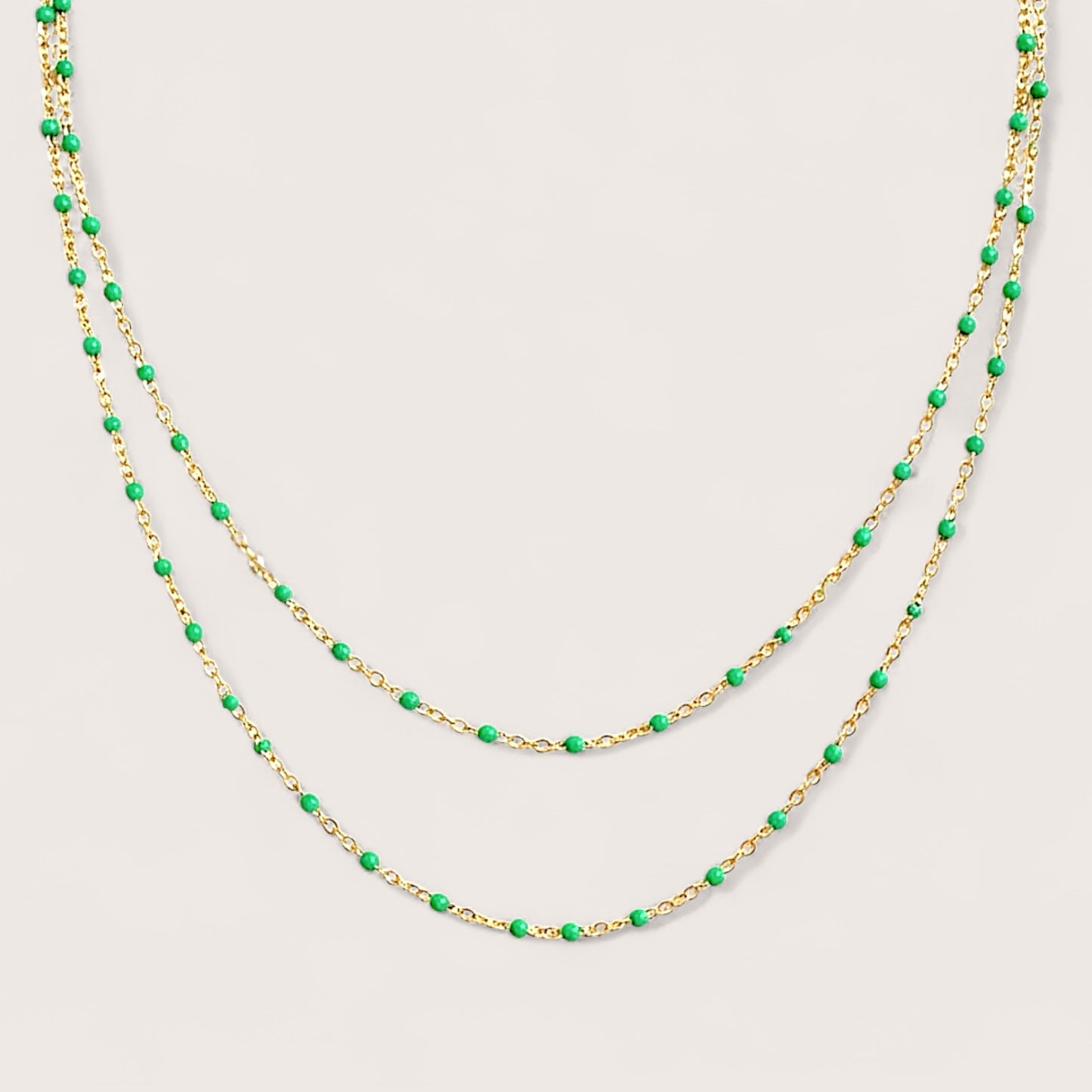 Macro view of the delicate station necklace showcasing the smoothly integrated emerald green enamel stations and certified 14/20 gold filled components.