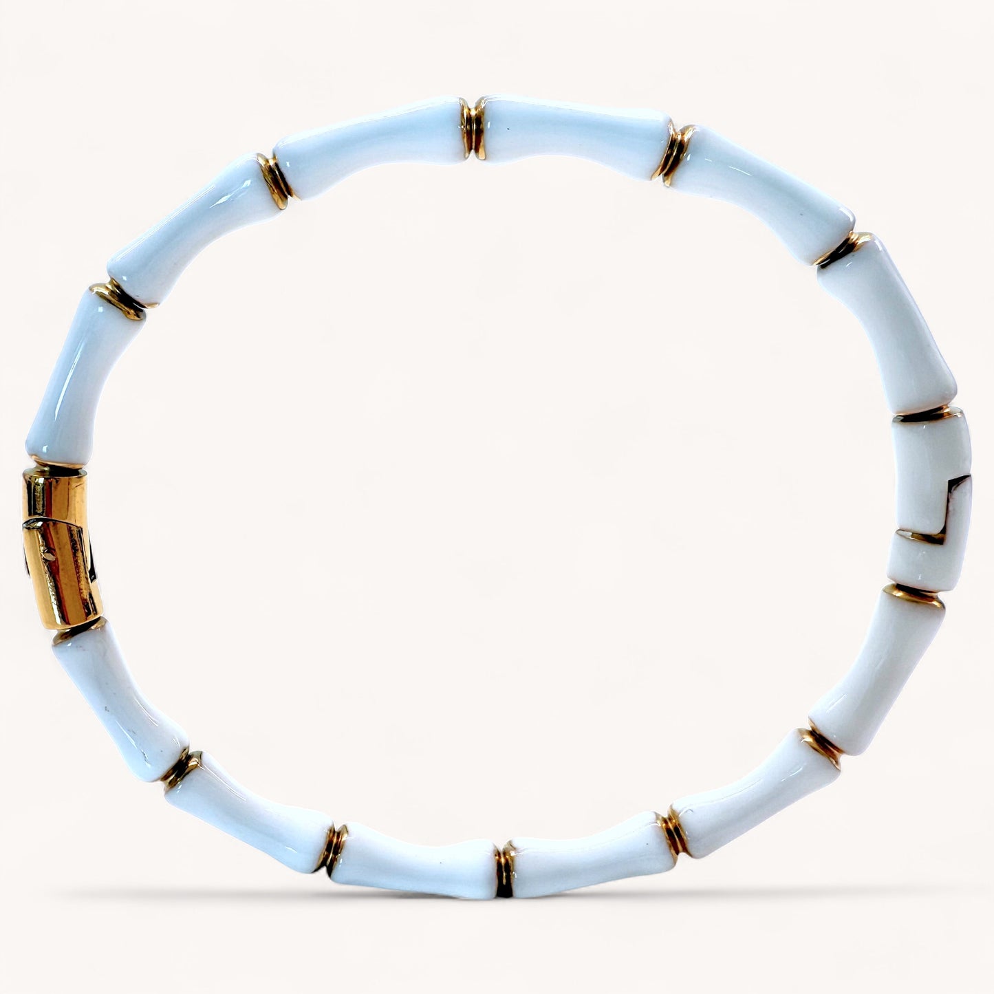 Close up image of 18k gold plated stainless steel bamboo bangle bracelets with high gloss White color enamel finish showing details of the geometric wood inspired nodes by Ashley Nicole Jewelry.