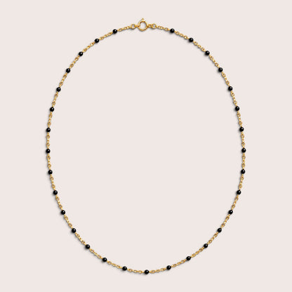 Black enamel station beads spaced along a gold-filled necklace