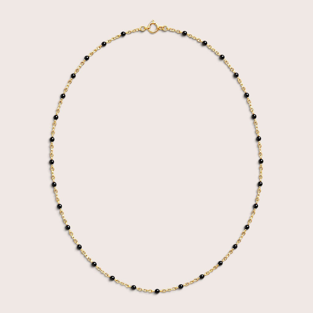 Black enamel gold satellite necklace arranged in an oval, with the spring-ring clasp visible at the top.
