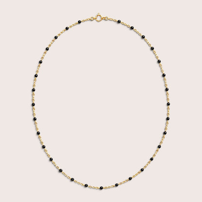 Black enamel gold satellite necklace arranged in an oval, with the spring-ring clasp visible at the top.