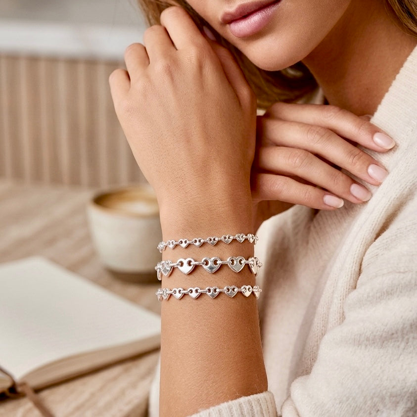 Model wearing the 4.5mm 6mm and 8mm chunky Italian solid sterling silver puffed mariner heart link bracelet styled in a stack by Ashley Nicole Jewelry