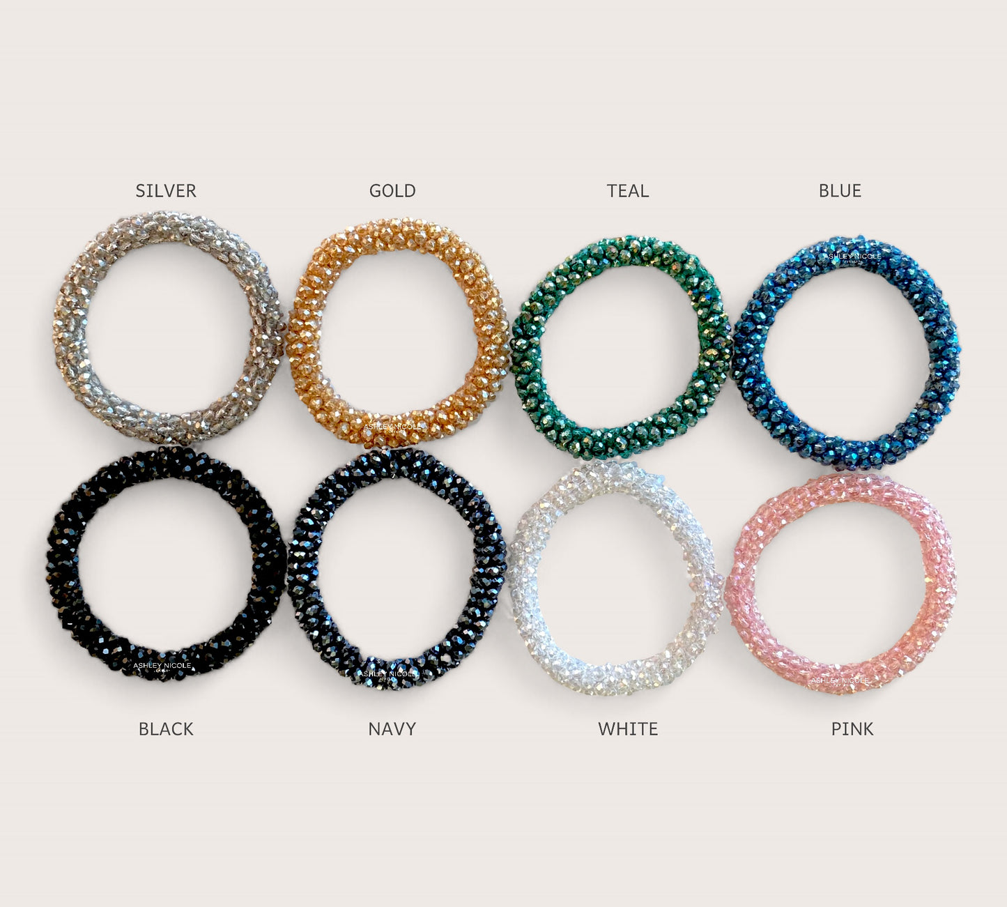 High-shine crystal bead elastic hair ties laid flat on a clean background showing the multi-faceted in black, silver, gold, teal blue, white, and pink, glass beads and woven stretch band by Ashley Nicole Jewelry. 