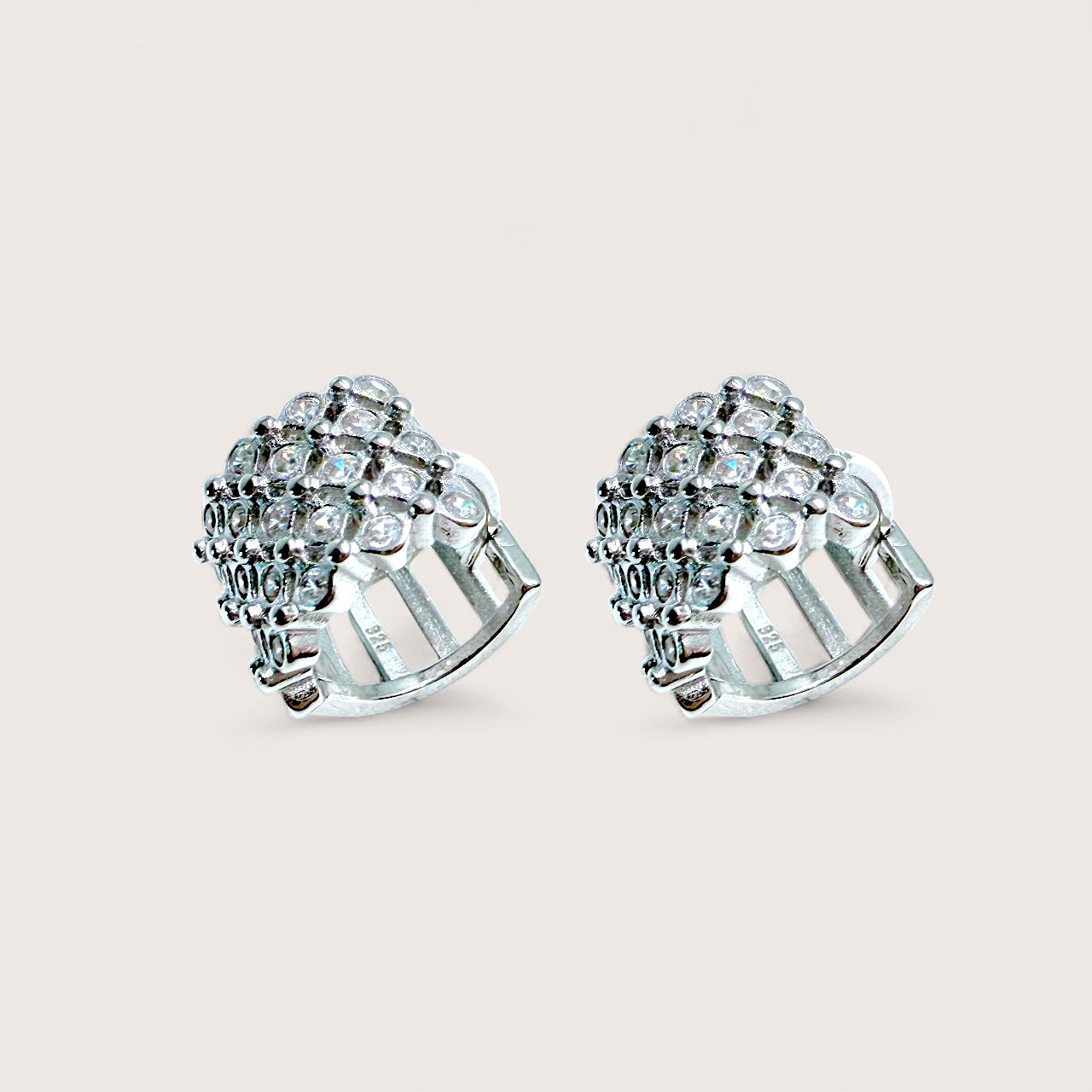 Pair of silver earrings with gemstones on a light beige background