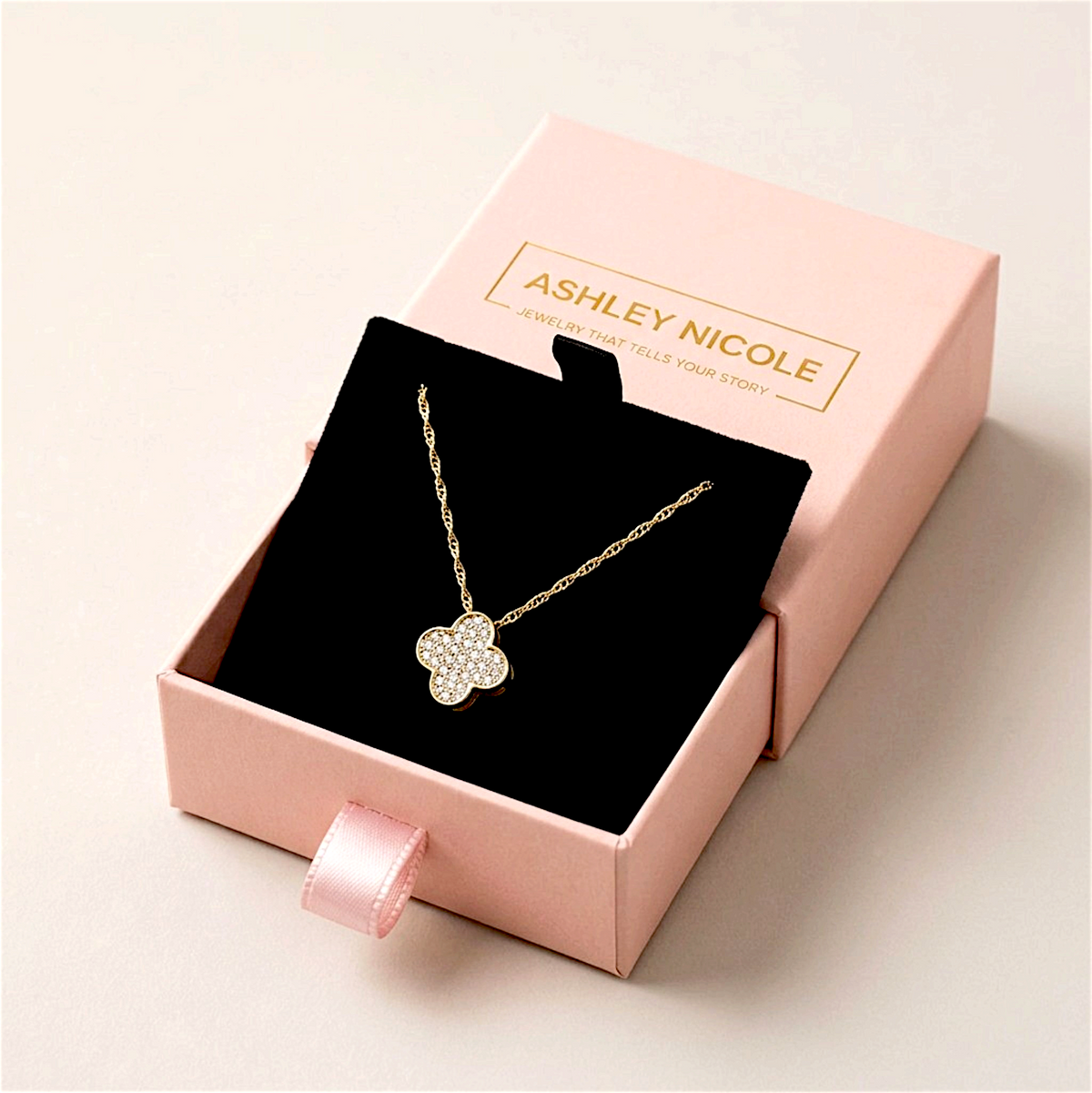 Diamond clover necklace on a black insert in an open pink Ashley Nicole Jewelry drawer box
