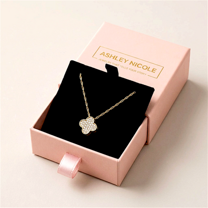 Diamond clover necklace on a black insert in an open pink Ashley Nicole Jewelry drawer box