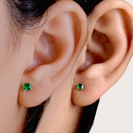 Professional ear-stack presentation featuring a small3.4mm and 4.3mm solid gold square emerald stud styled flawlessly on a model ear lobe side by side 