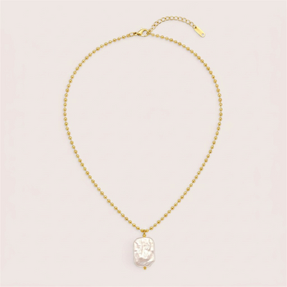 Full gold ball chain necklace laid flat with a white baroque pearl pendant, lobster clasp, and extension chain.