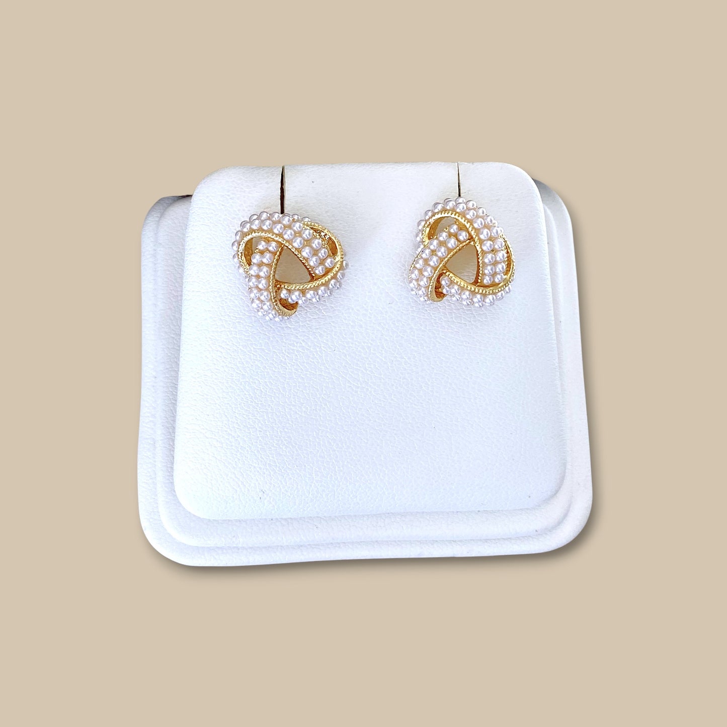 18K gold pearl knot earrings on a display showing the close up details of the knot and pearls
