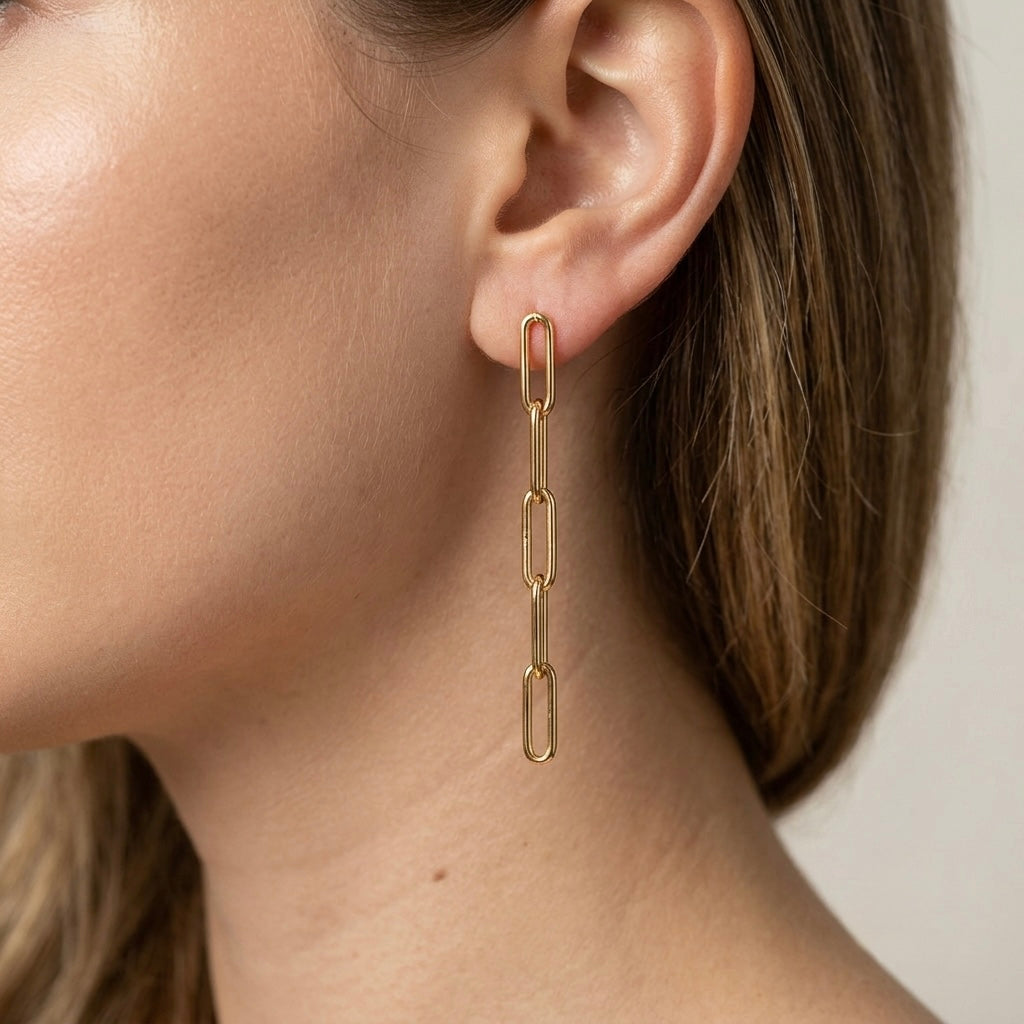 A model wearing 2.5-inch paperclip chain drop earrings in 14K gold-filled for a clean, minimalist everyday look by Ashley Nicole Jewelry