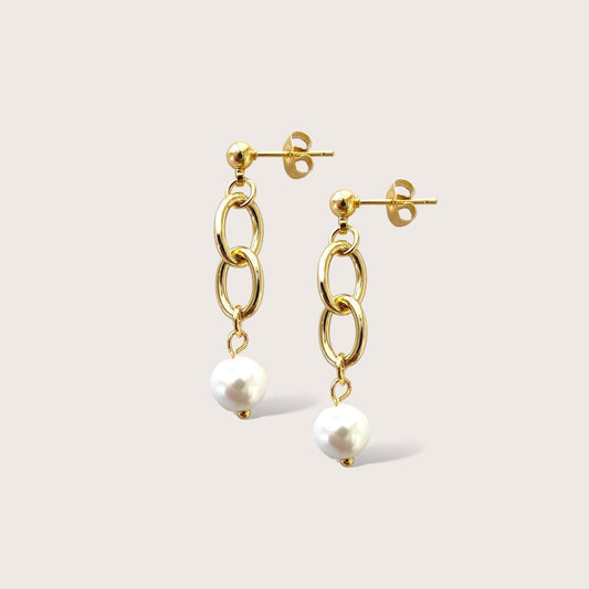Our Dangling Pearl Earrings add elegance to any outfit. These unique earrings feature a dangling pearl at the end of a gold chain, perfect for any occasion. With a push-back post, they're easy to wear and add a playful touch to your everyday look. Why not have a little fun with your accessories?