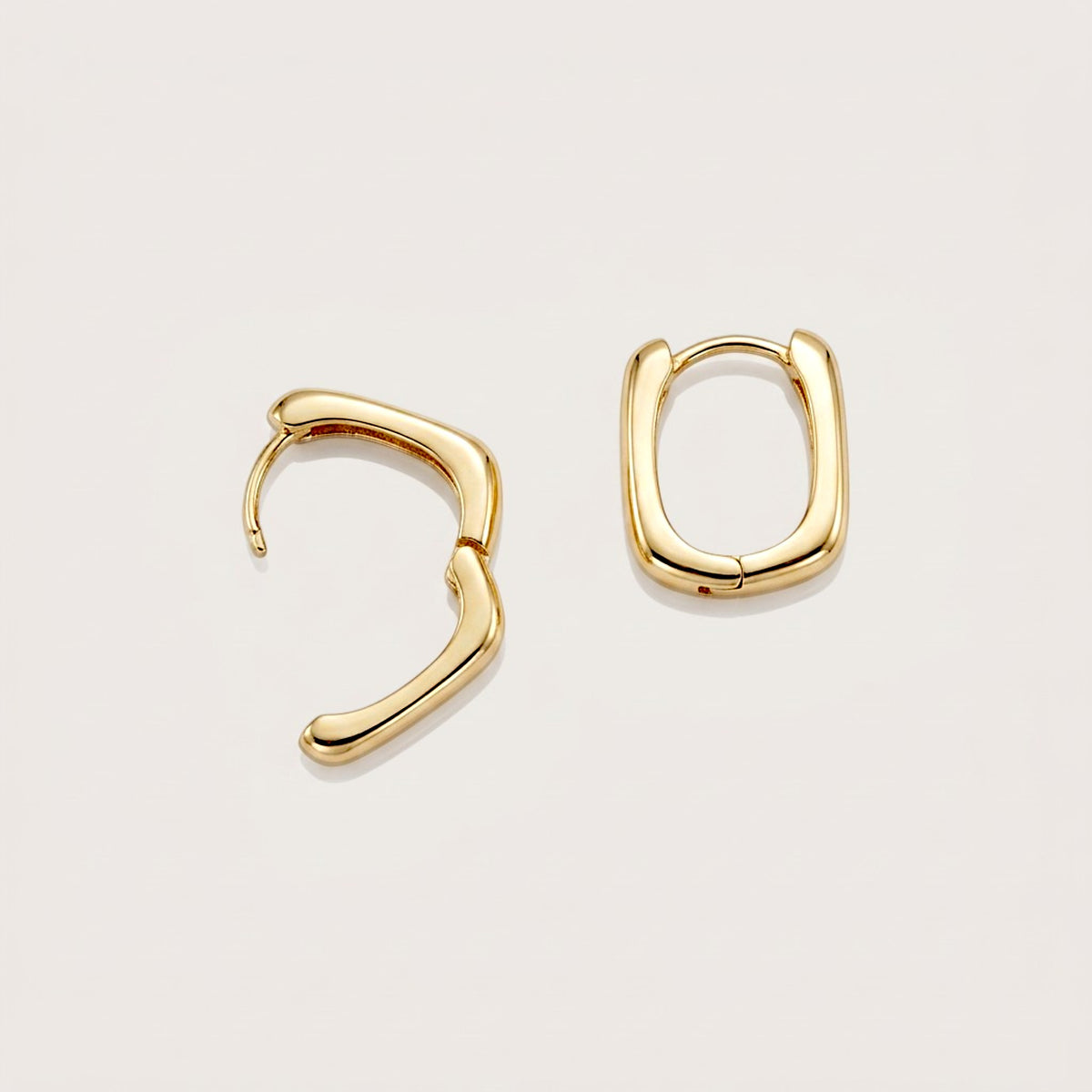 Gold rectangular huggie earrings with one hoop open and one closed, showing the hinged fastening and curved post.