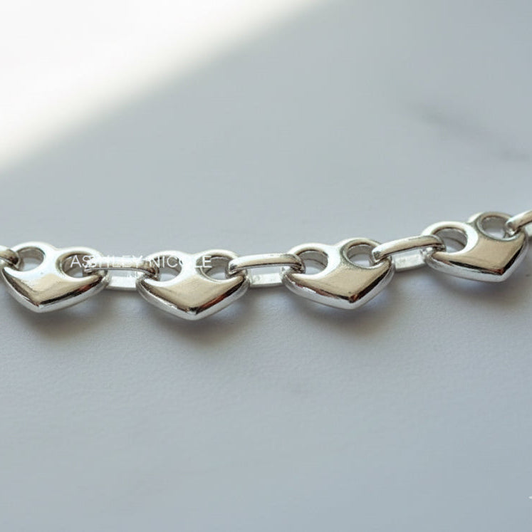 Close-up of chunky solid silver puffed heart mariner links bracelet