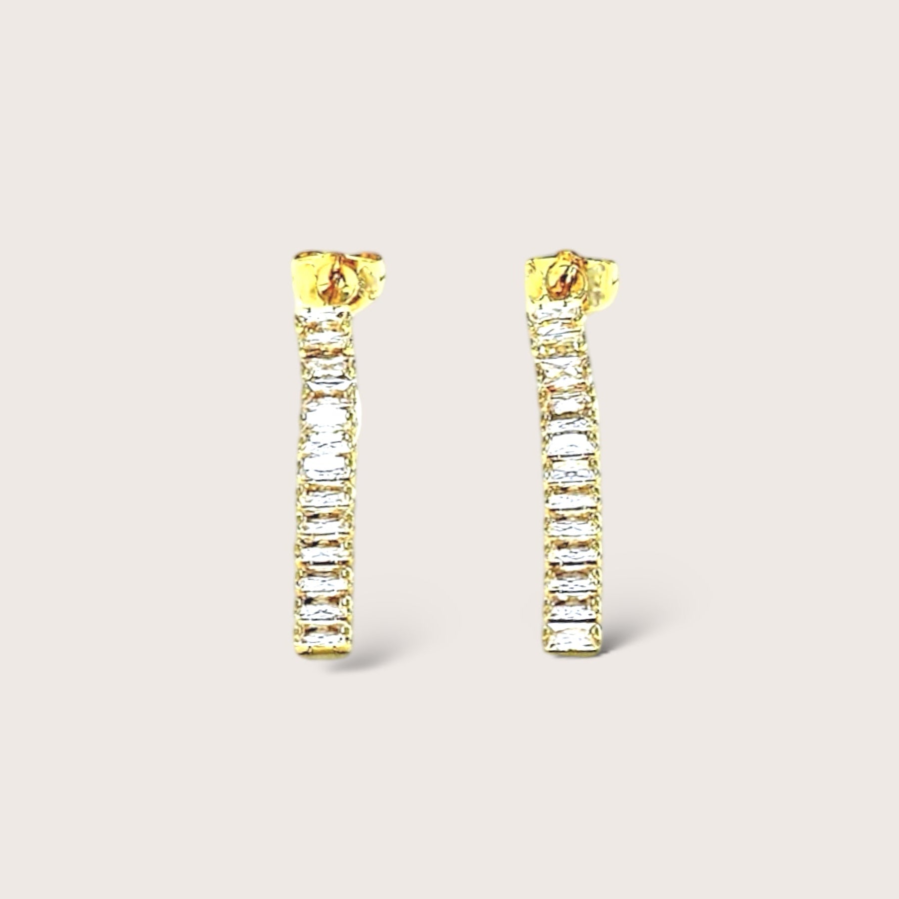 Infuse your ensemble with a touch of refined luxury by adorning yourself with our gold &amp; clear crystal baguette dangle earrings. Fashioned with sparkling gemstones encased in 18K gold, these opulent earrings are ideal for any occasion and make a sophisticated and meaningful present for those with impeccable taste.