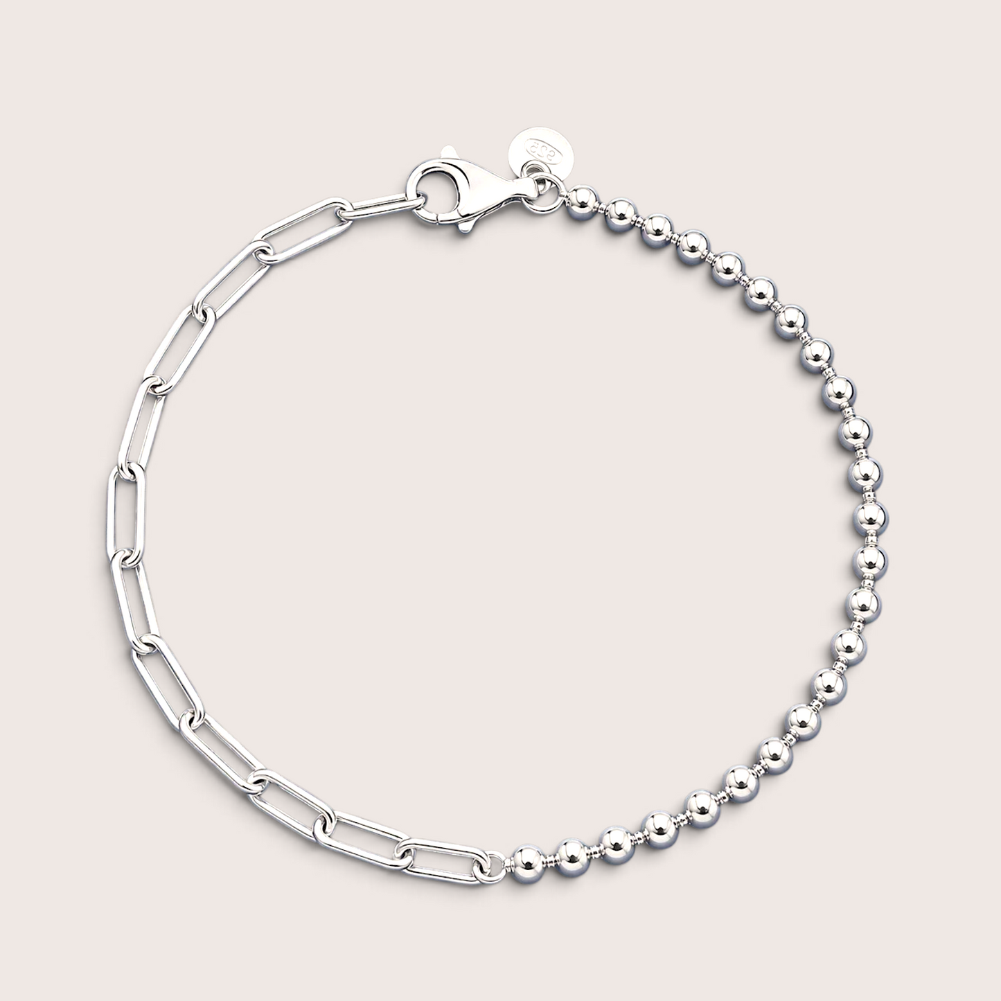Flat lay of an Italian mixed link chain bracelet in polished 925 sterling silver resting on a solid light background, showcasing the asymmetrical 3mm bead strand and paperclip chain.