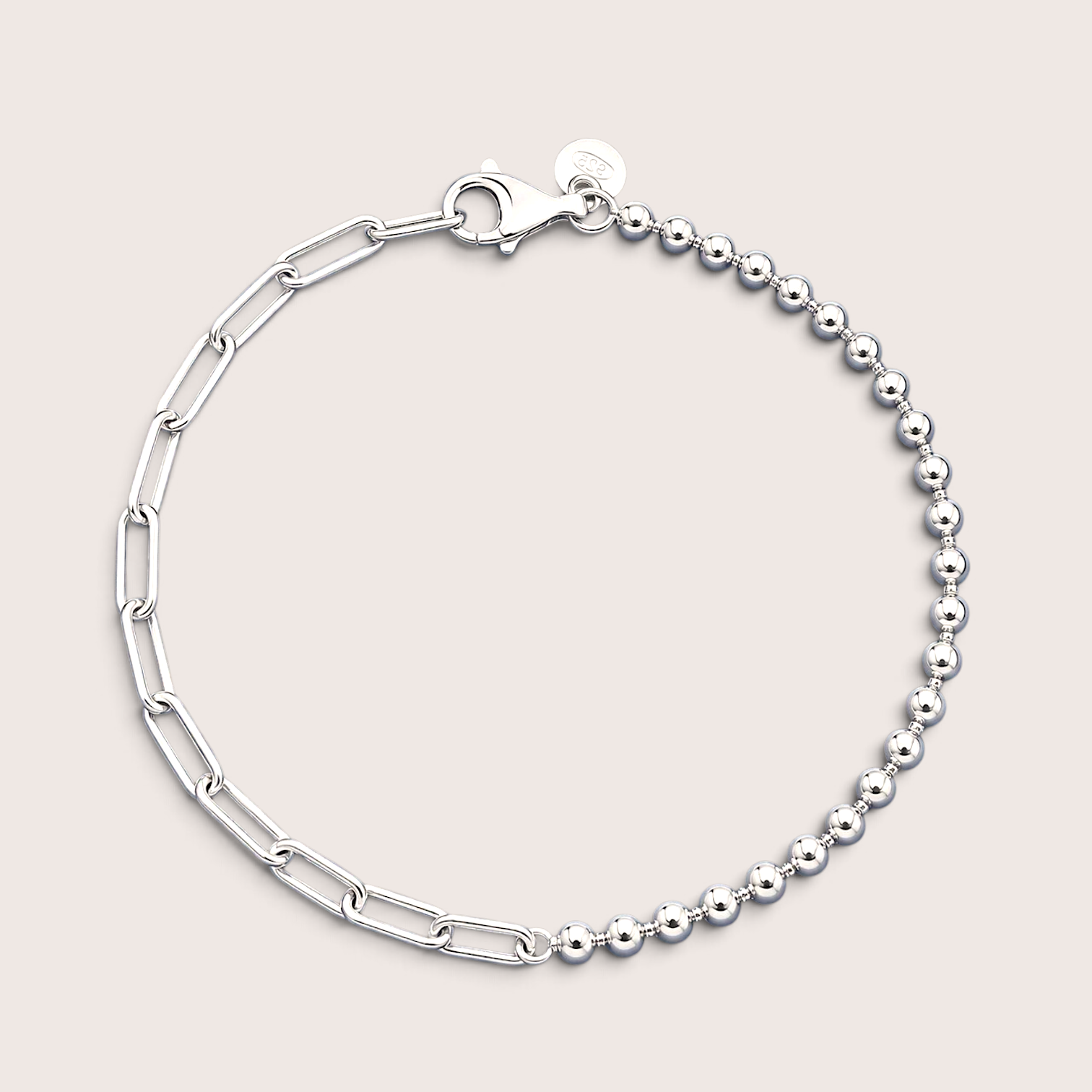 Flat lay of an Italian mixed link chain bracelet in polished 925 sterling silver resting on a solid light background, showcasing the asymmetrical 3mm bead strand and paperclip chain.