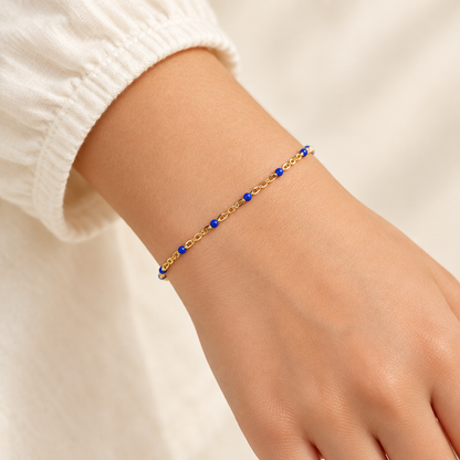 Sapphire blue enamel and gold-filled bracelet worn on a child-sized wrist