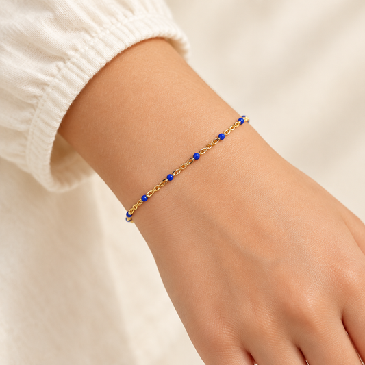 Sapphire blue enamel and gold-filled bracelet worn on a child-sized wrist