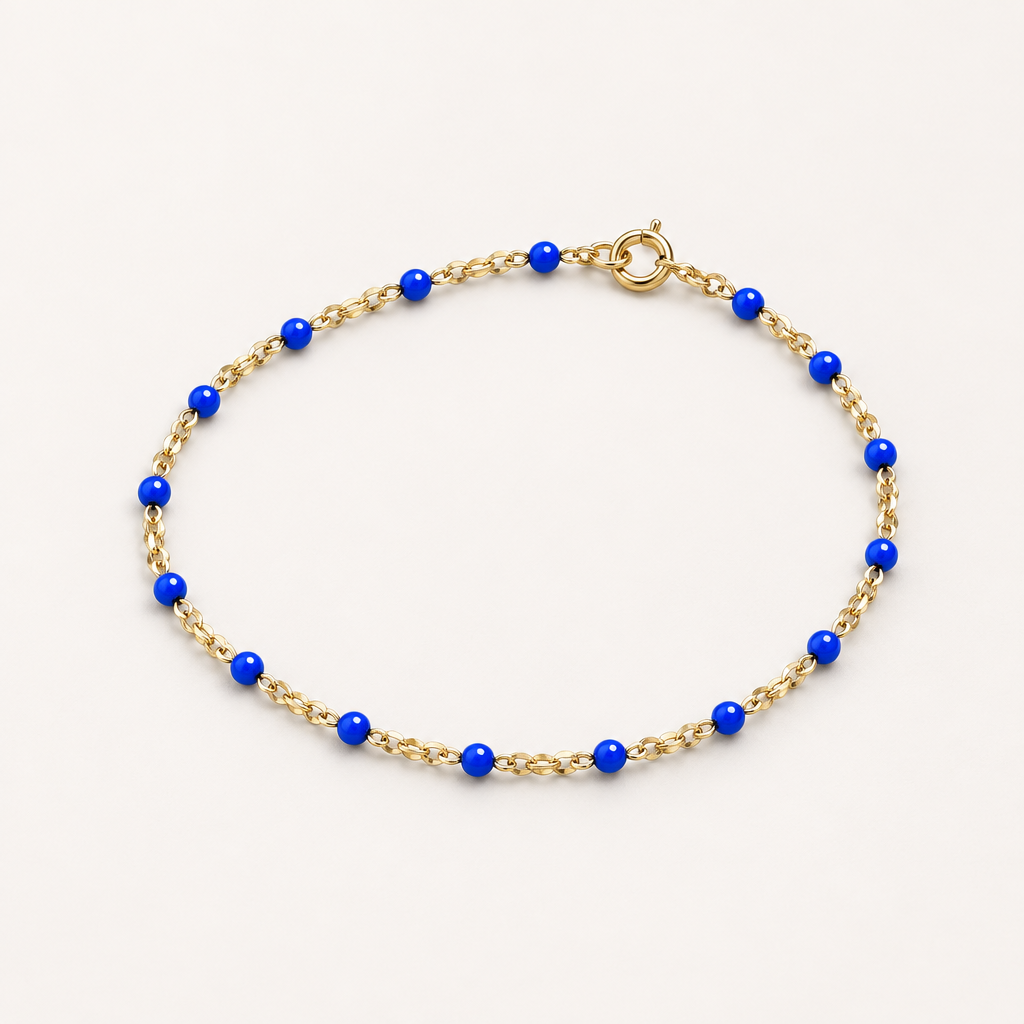 Three-quarter studio view of a kids’ blue enamel and 14K gold-filled bracelet