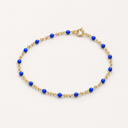 Three-quarter studio view of a kids’ blue enamel and 14K gold-filled bracelet