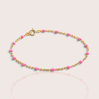 Elevated studio view of a kids’ light pink enamel bracelet with a 14K gold-filled chain