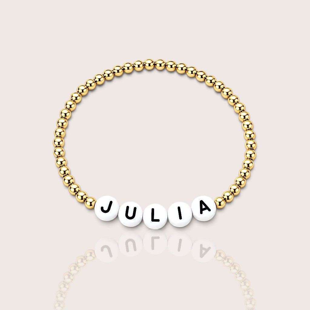 Kids personalized bracelet spelling a custom name with 14K gold-filled beads and white letter beads