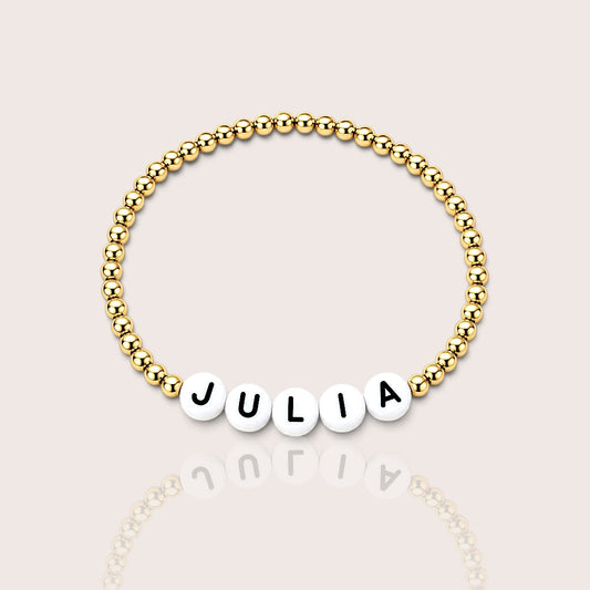 Kids personalized bracelet spelling a custom name with 14K gold-filled beads and white letter beads