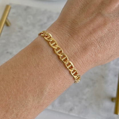 Model wearing a dainty 14k gold filled flat mariner link chain bracelet styled in a delicate everyday stack by Ashley Nicole Jewelry⁠