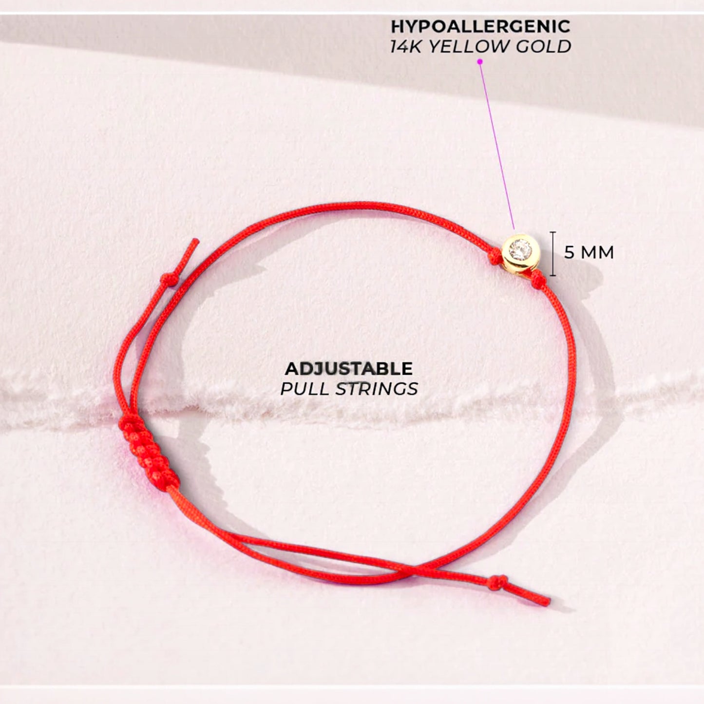 Flat lay close up of an adjustable red string bracelet with a 5mm 14k gold bezel charm, the bracelet is made of red silky nylon and is adjustable with a sliding knot. 