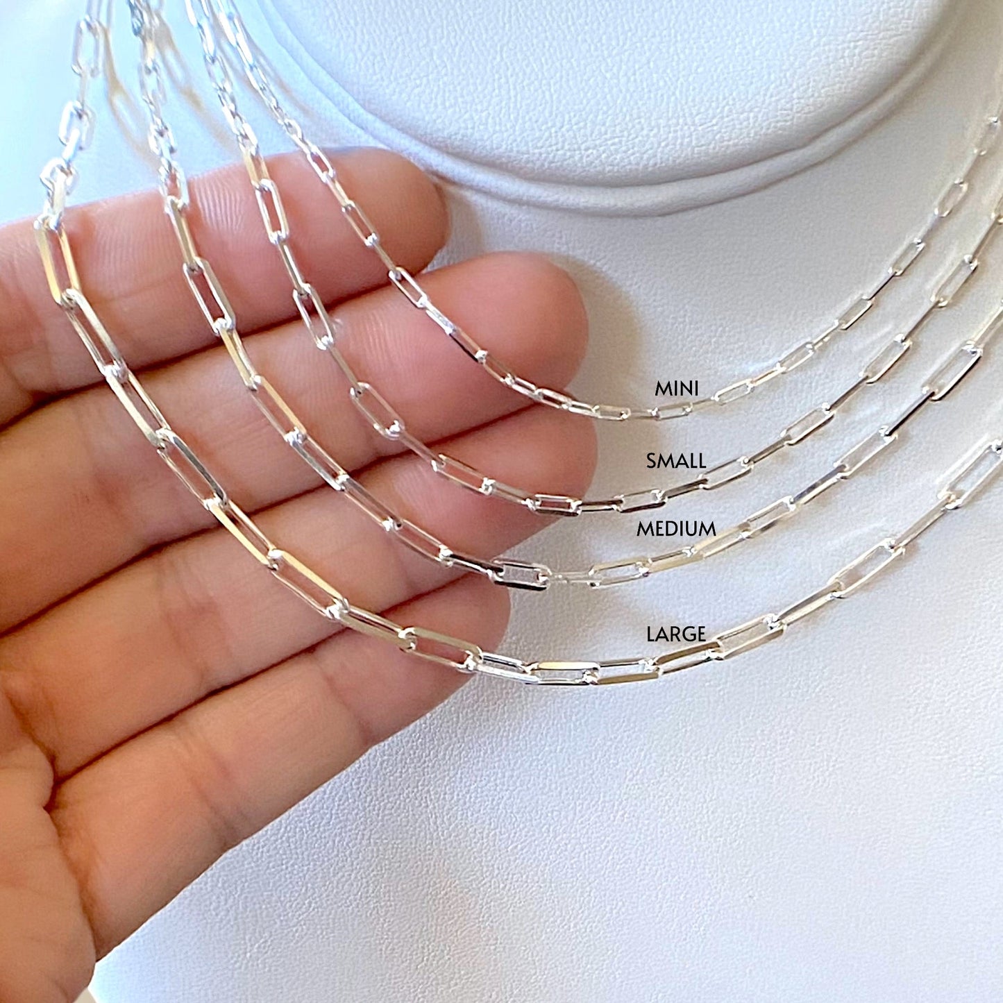 Close up of Sterling Silver Paperclip Chains with size labels, mini, small, medium and large 