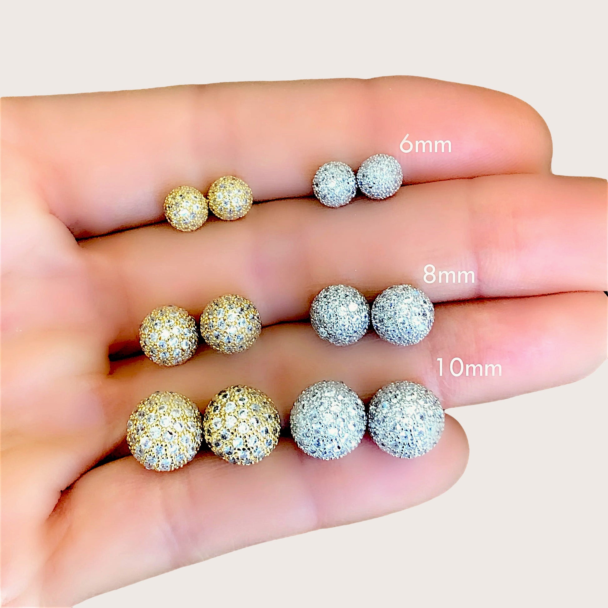 10mm geometric crystal sphere stud earrings on a minimalist background showing high-shine metallic finish.