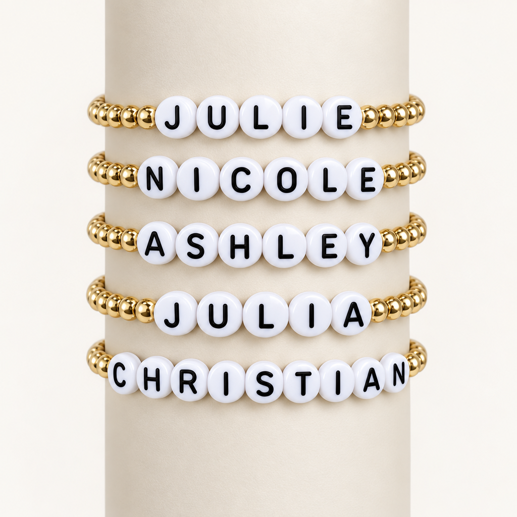 Five personalized kids’ name bracelets displayed with gold-filled beads and white letter beads