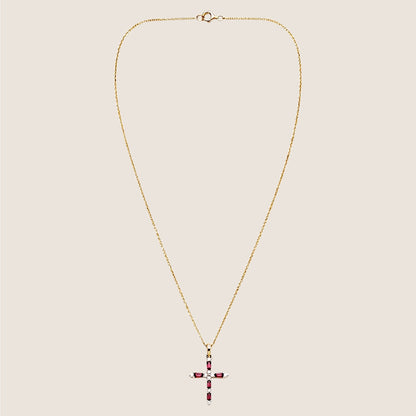 Entire ruby and diamond cross necklace laid flat, with the fine gold chain and spring-ring clasp visible