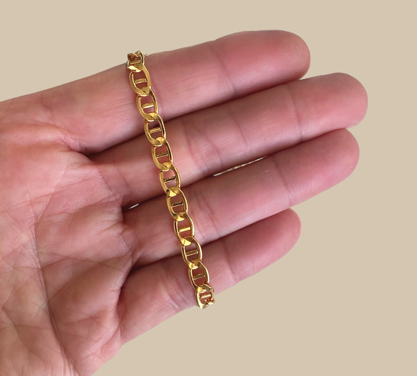 14k gold filled flat mariner link chain bracelet in a hand by Ashley Nicole Jewelry