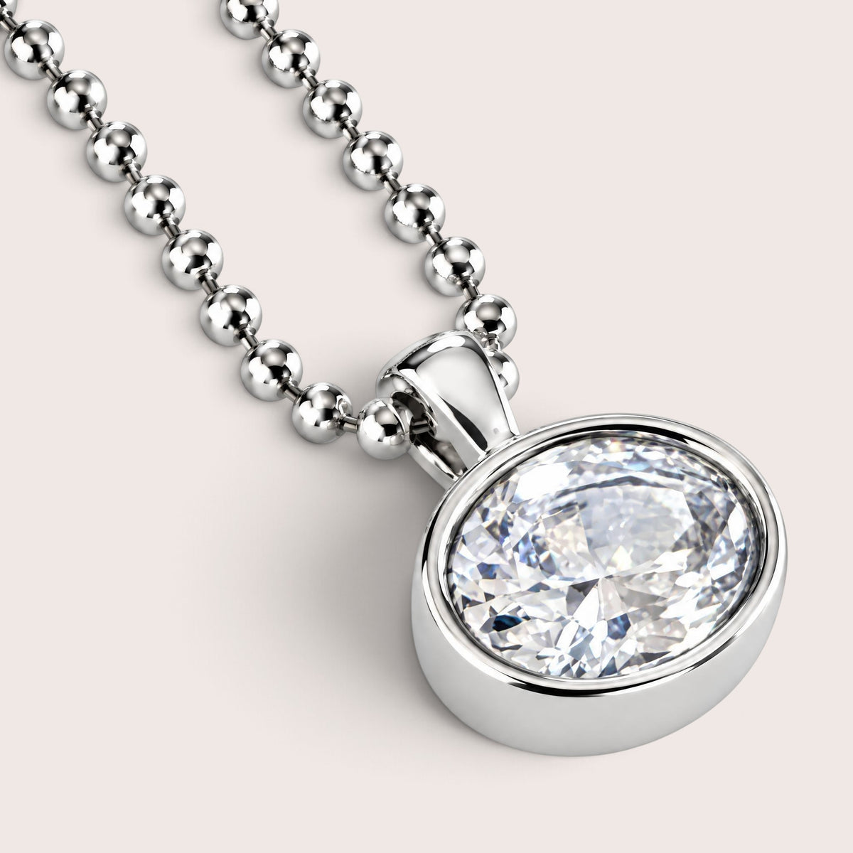 A silver ball chain necklace with an oval bezel-set clear gemstone pendant, shown on a clean white background.