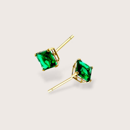 Macro detail shot of a princess cut lab emerald stud highlighting the sleek 14K solid gold basket 4-prong setting and authenticated gold stamp post.