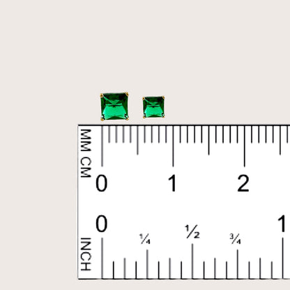 3.4mm and 4.3mm emerald studs compared on a ruler.