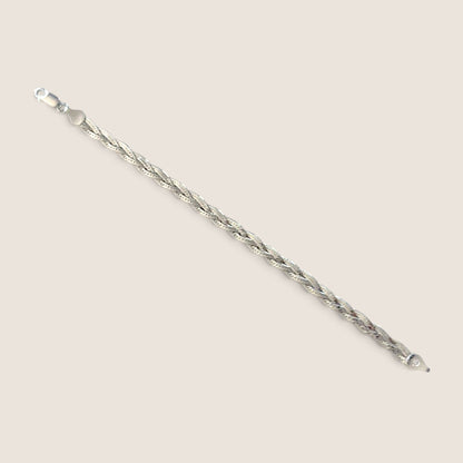 Sterling silver braided herringbone bracelet laid open diagonally with both clasp ends visible