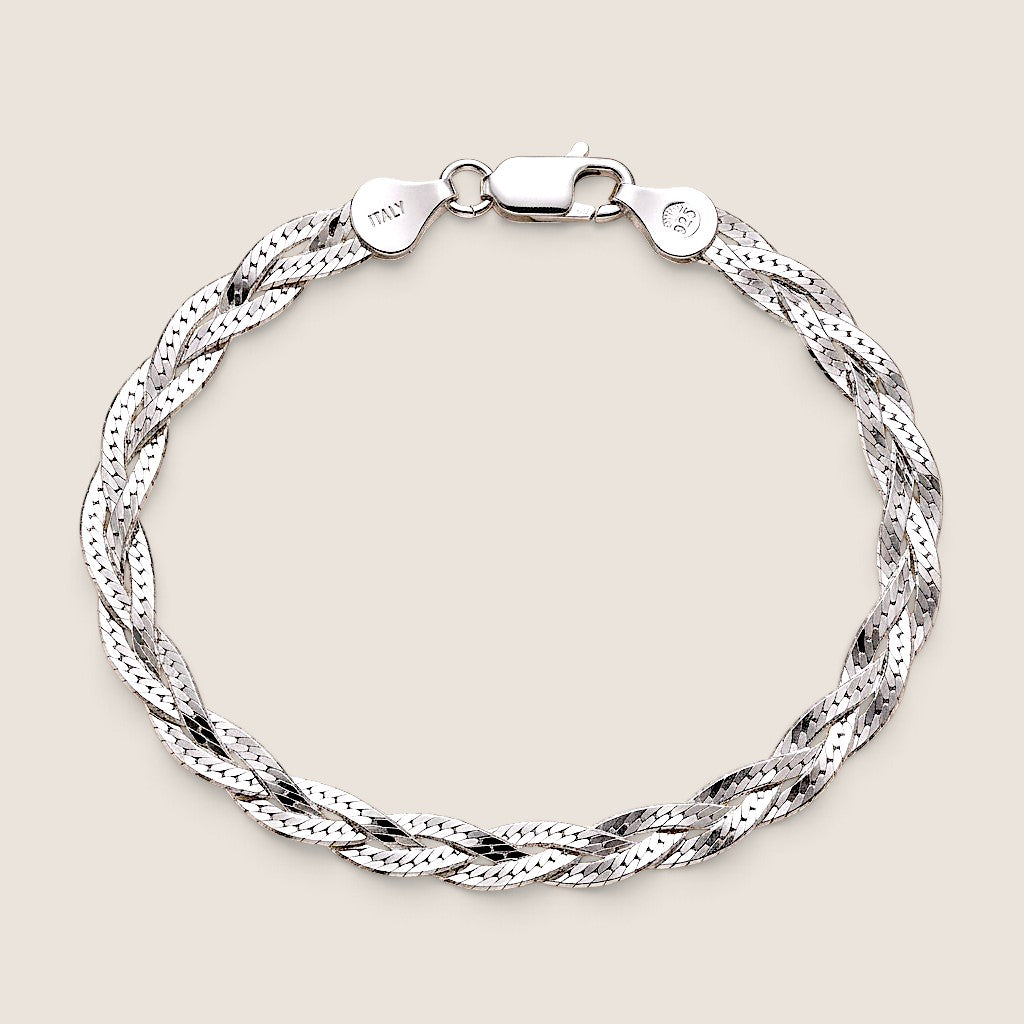 Overhead view of a sterling silver braided herringbone bracelet with lobster clasp