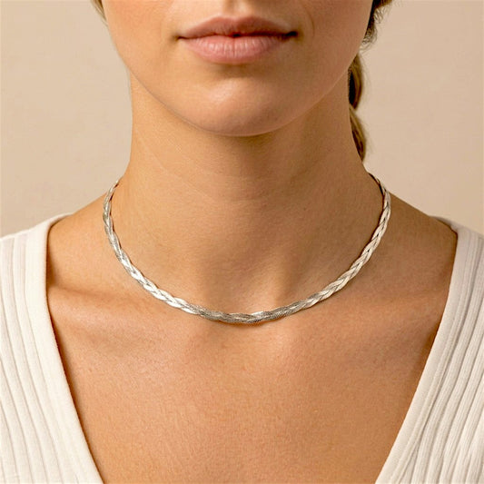 Single sterling silver braided herringbone necklace worn close to the base of the neck