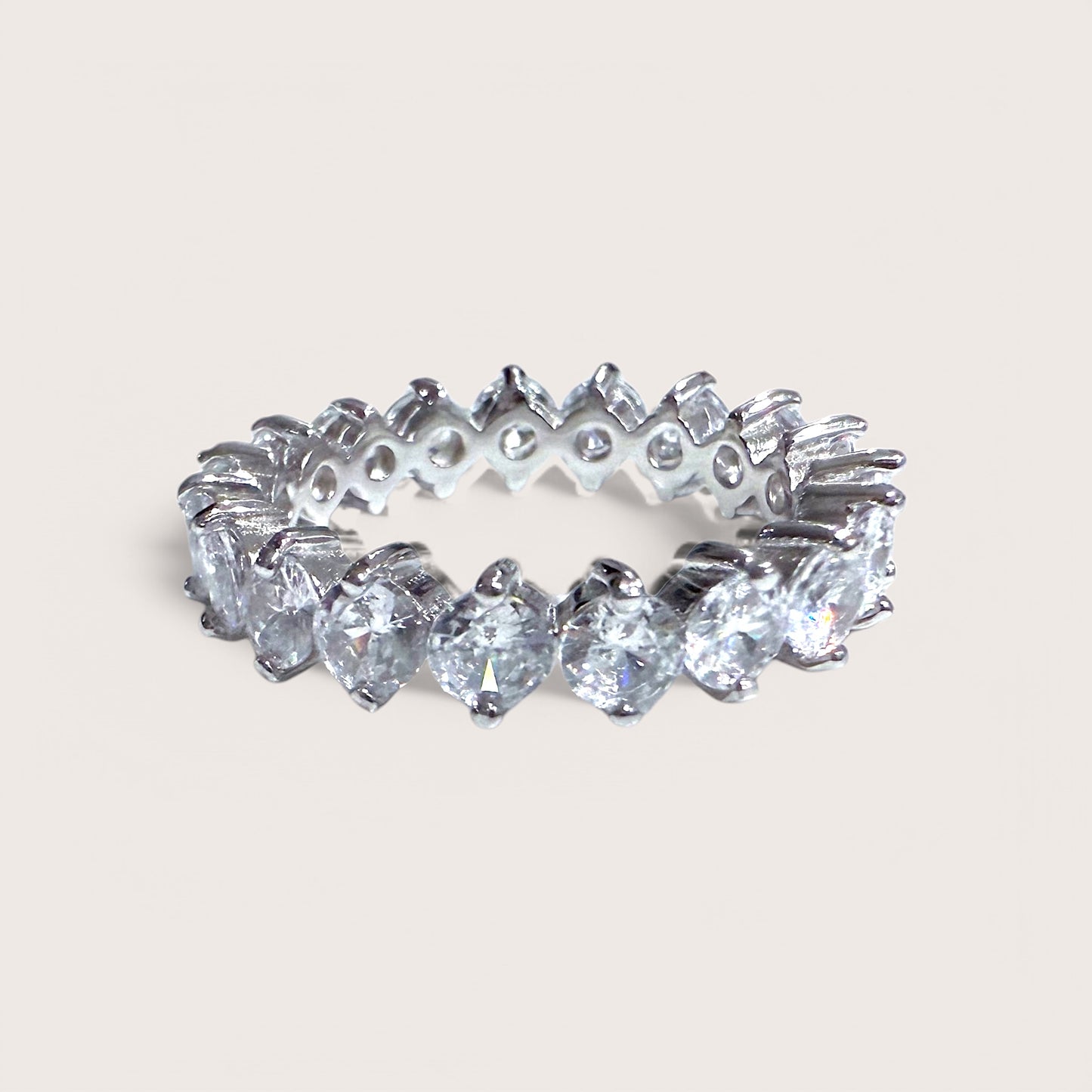 A sterling silver eternity band ring with round cut cubic zirconia stones throughout.