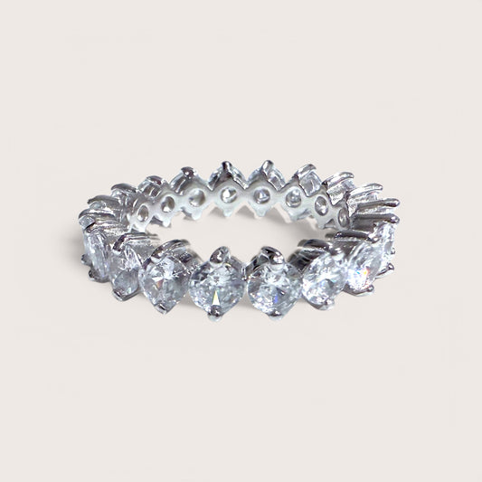 A sterling silver eternity band ring with round cut cubic zirconia stones throughout.