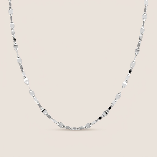 Sterling silver Valentino mirror link necklace arranged in a U shape on a warm neutral background