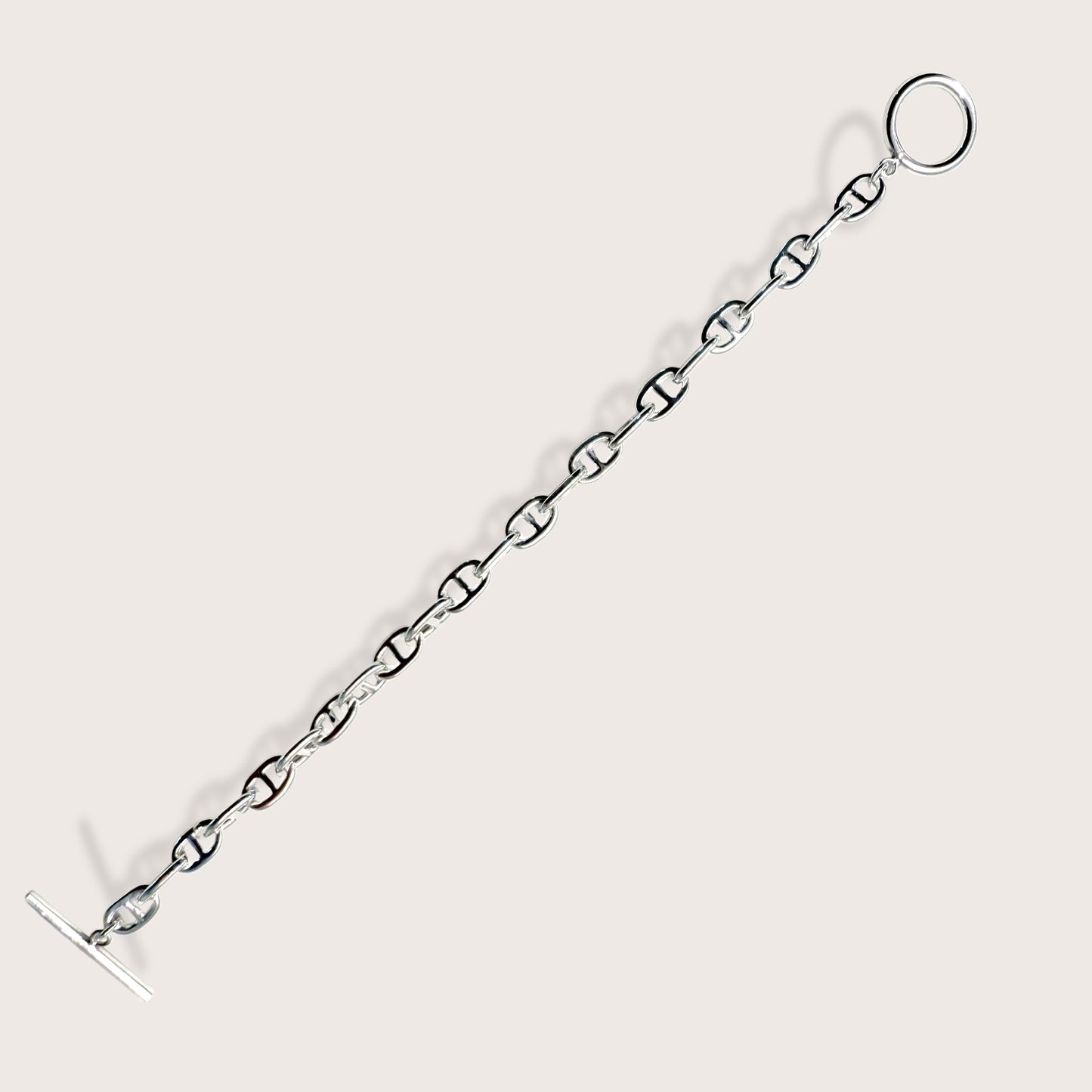 Side-angle view showing the weight and high-polish mirror shine of a silver anchor link bracelet
