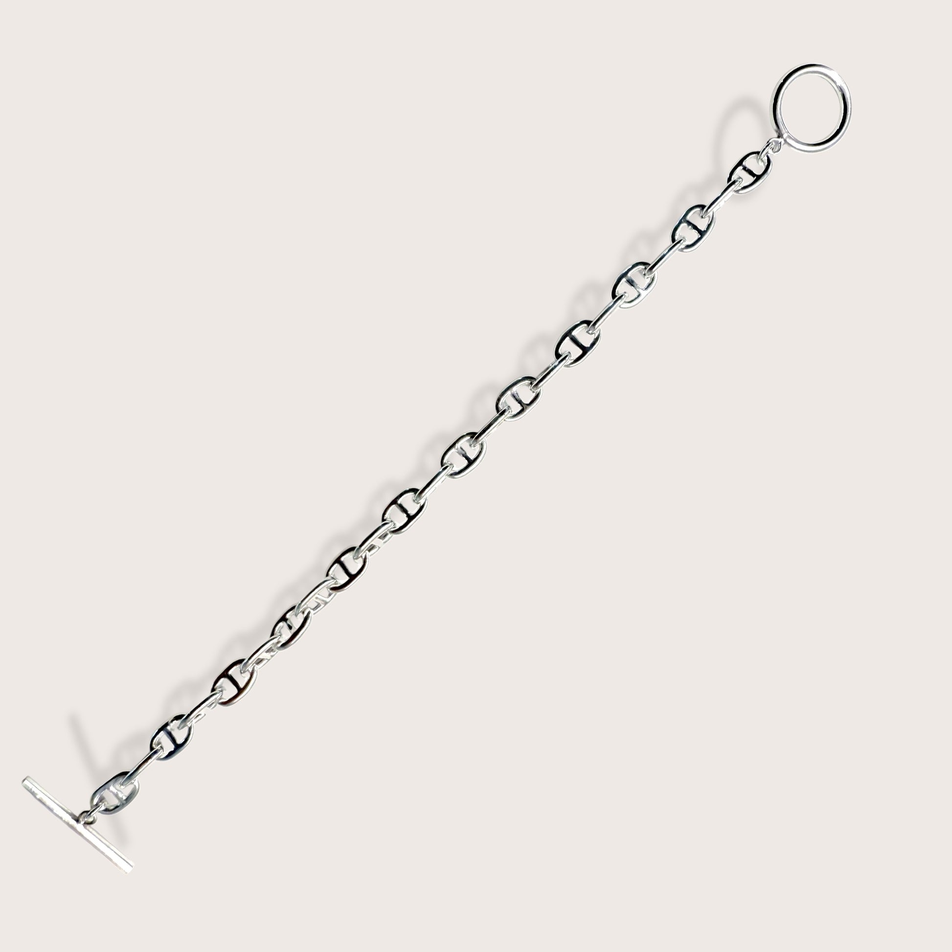 Side-angle view showing the weight and high-polish mirror shine of a silver anchor link bracelet