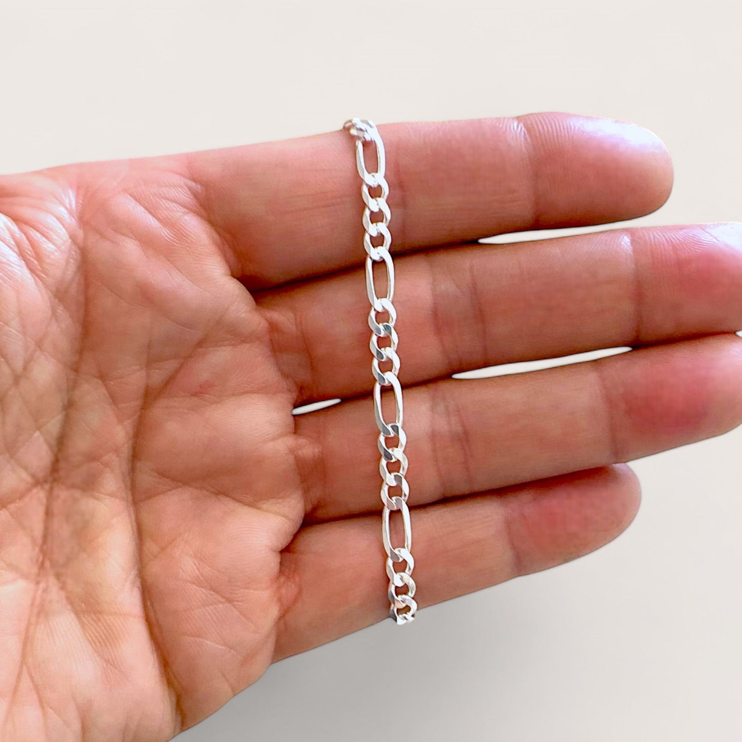A close up shot of the 4mm sterling silver Figaro bracelet link connectors ahighlighting the authentic Italian craftsmanship and brilliant polish.