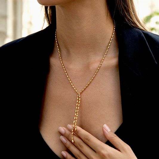 Woman wearing the Gold Oval-Bead Y Lariat Necklace with a black blazer